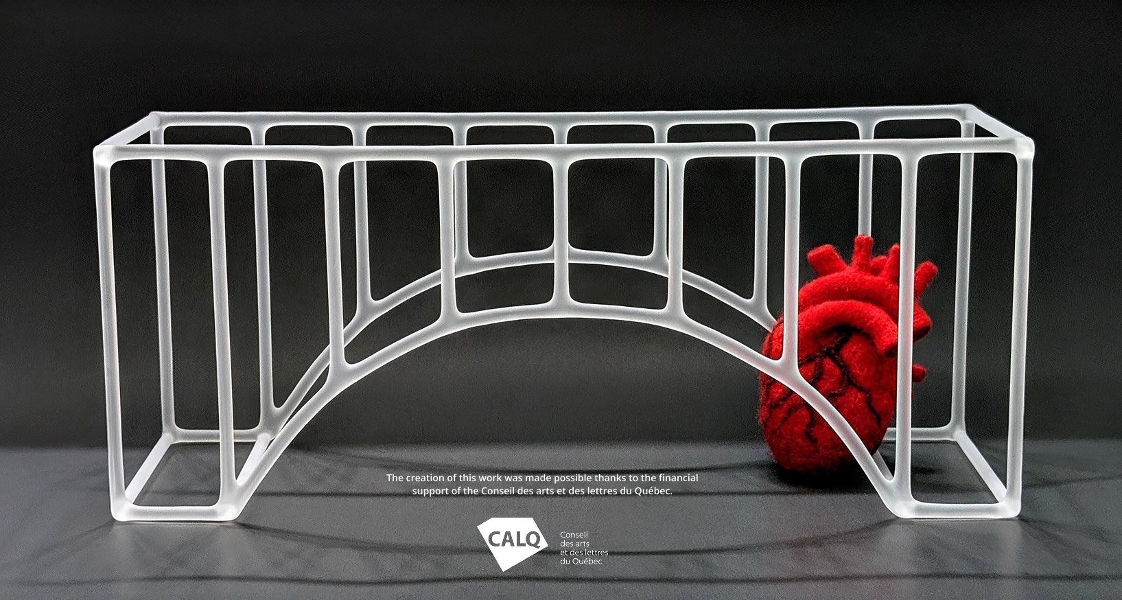 A glass sculpture of a bridge with a heart hiding underneath